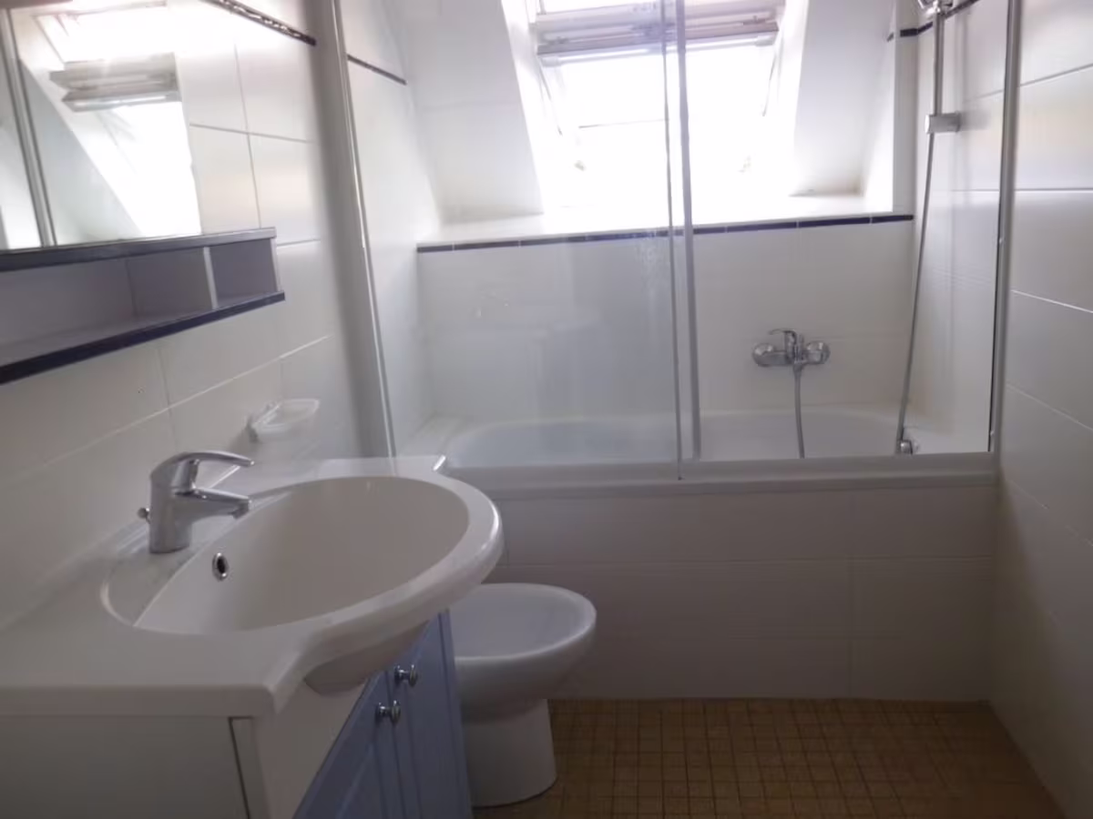 Modern bathroom with skylight and glass shower.