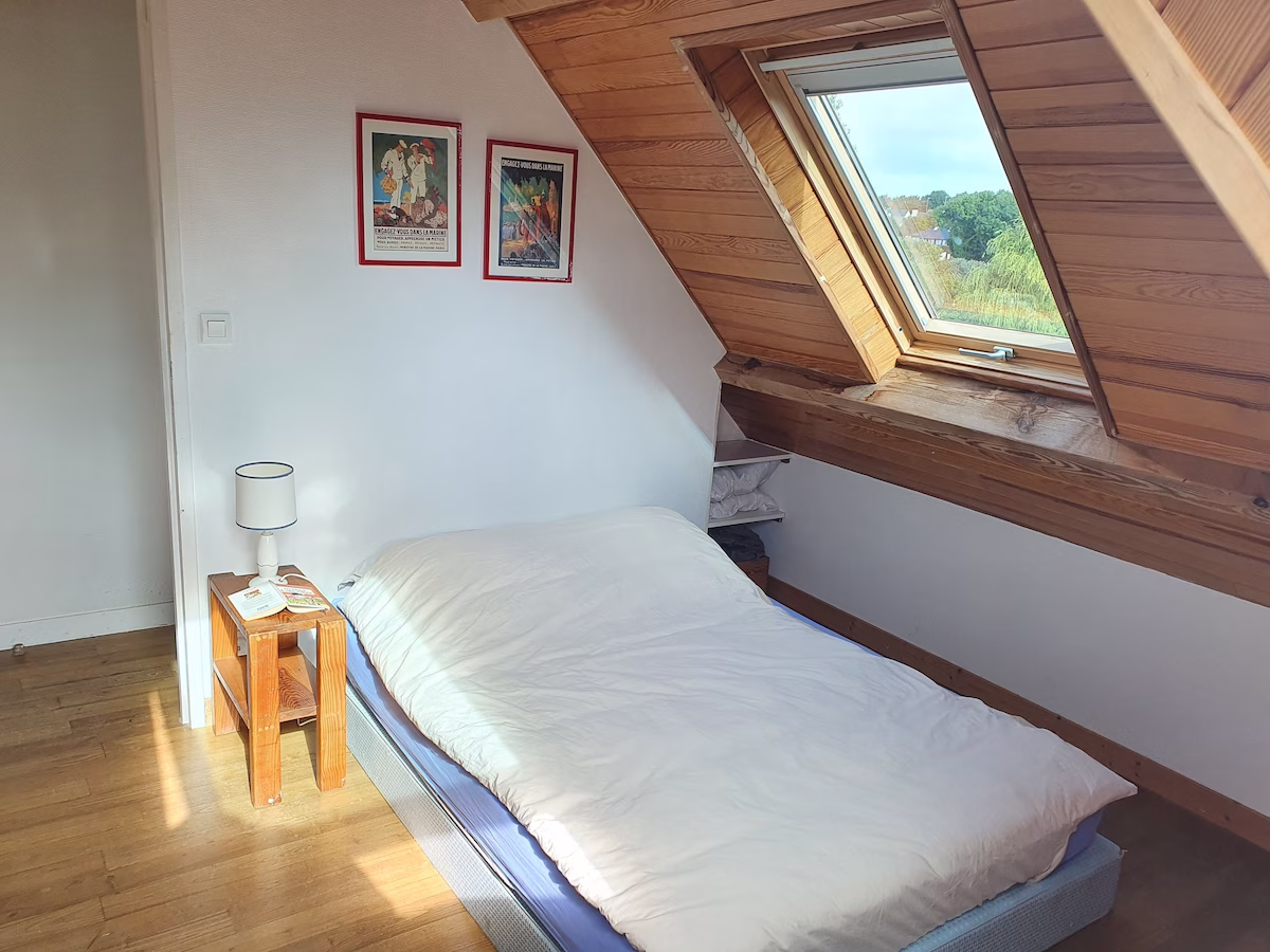 Cosy attic bedroom with skylight and wooden accents.