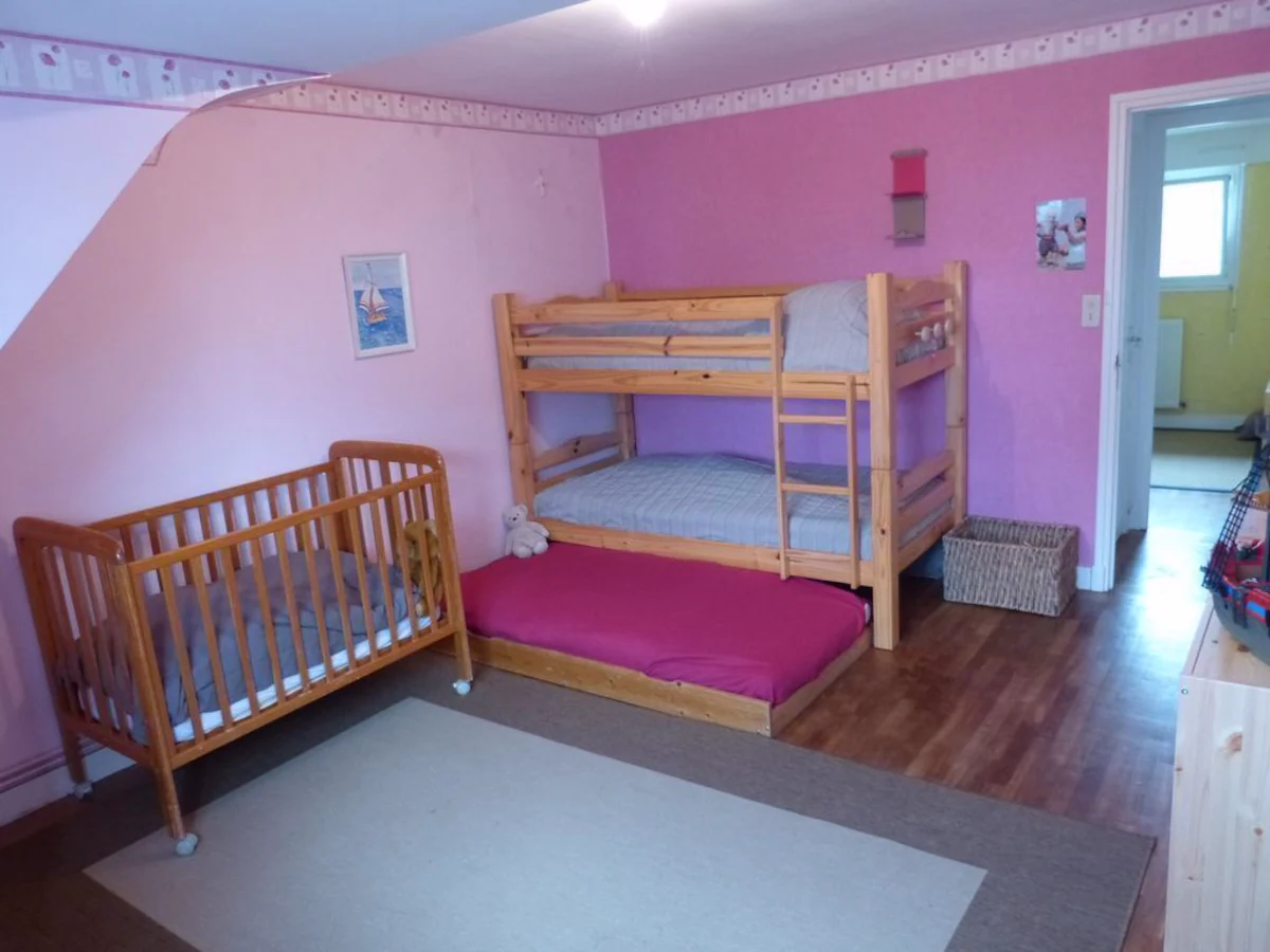 Pink child’s room with bunk bed and crib.