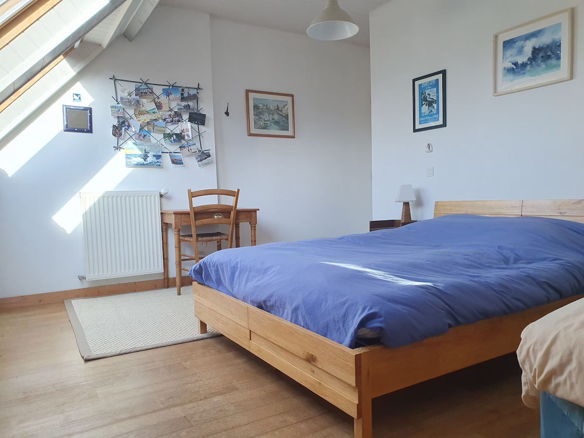 Cosy bedroom with skylight and wooden furniture.