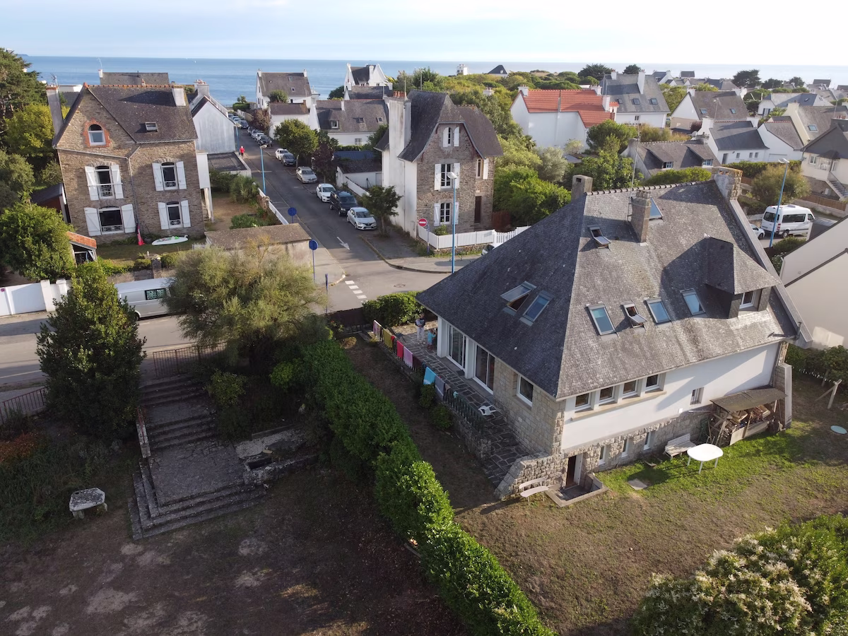 Seaside village with stone houses and gardens.