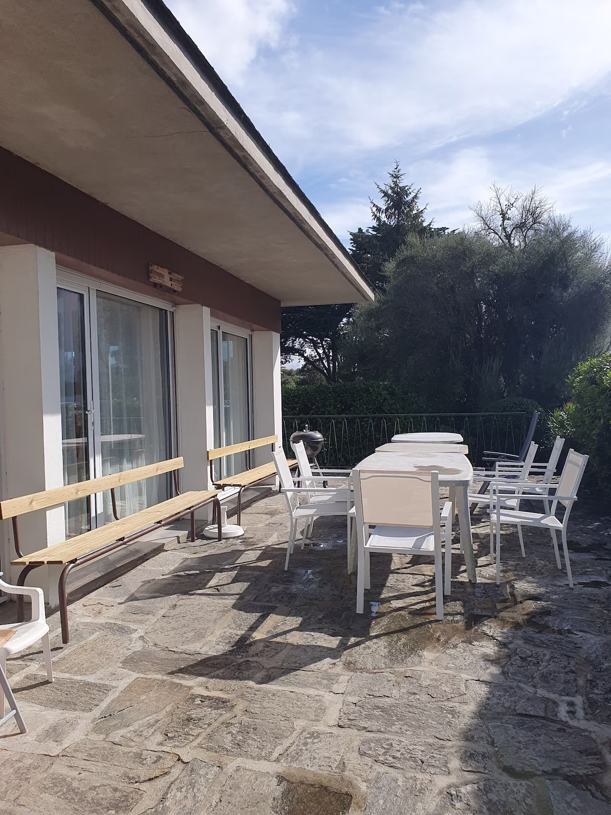 Outdoor patio with tables and chairs on sunny day.