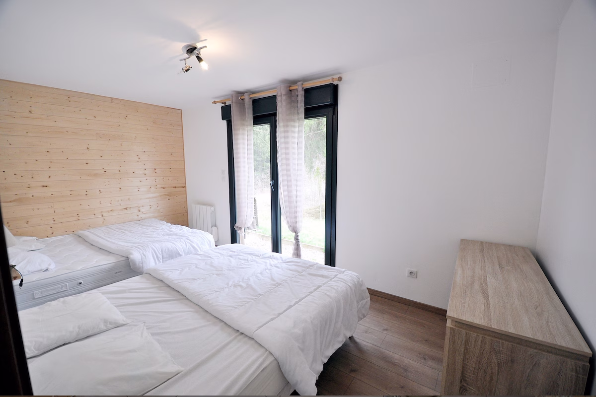 Minimalist bedroom with twin beds and wooden accents.
