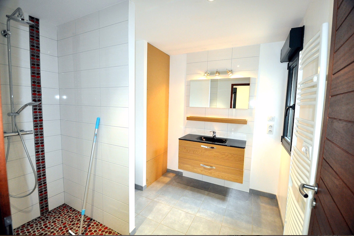 Modern bathroom with walk-in shower and sink.