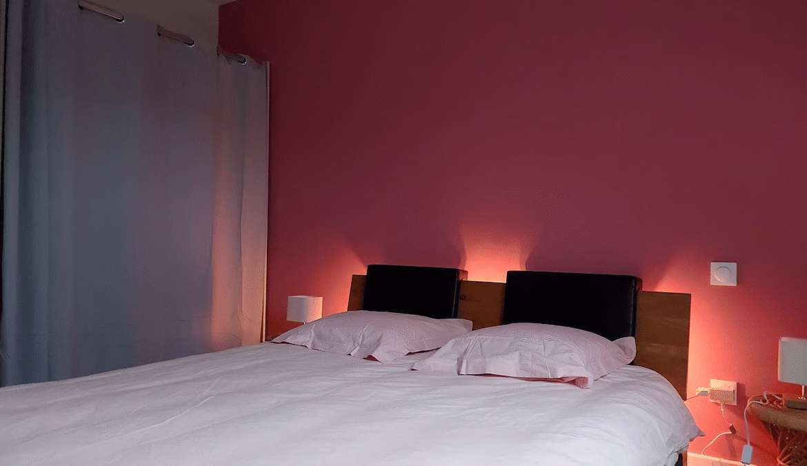 Cosy double bedroom with pink walls.