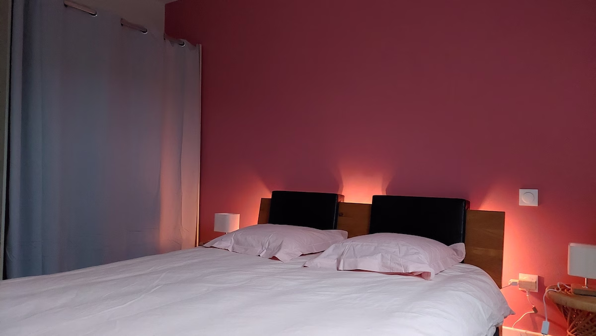 Cosy double bedroom with pink walls.