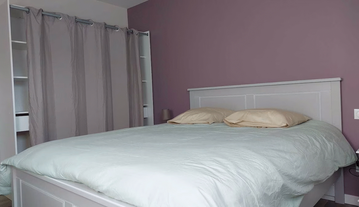 Modern bedroom with pastel colours and curtains.