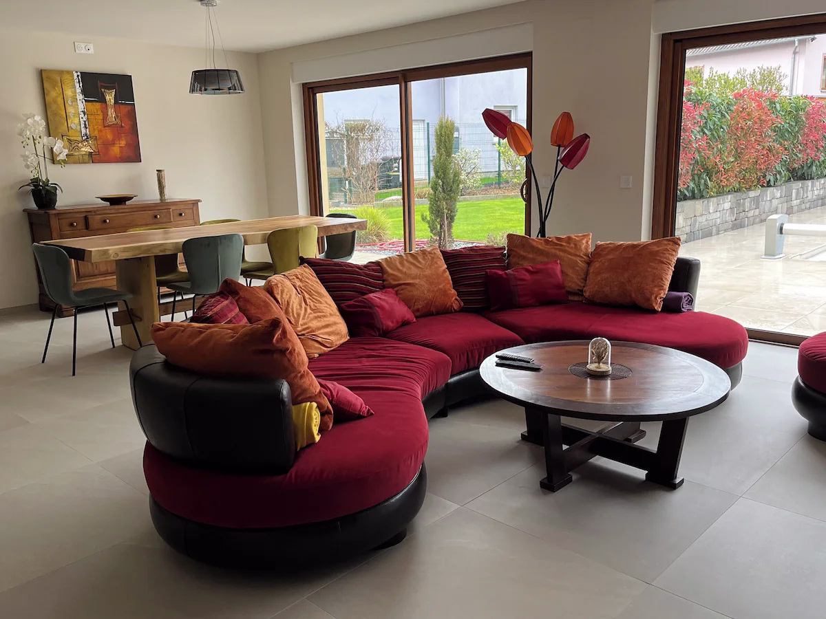 Modern lounge with sofa, table, and dining area.