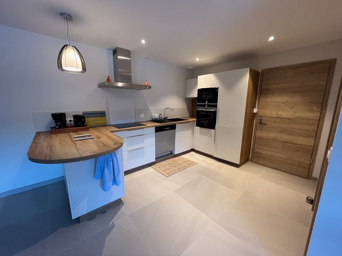 Modern kitchen with wooden accents and appliances.