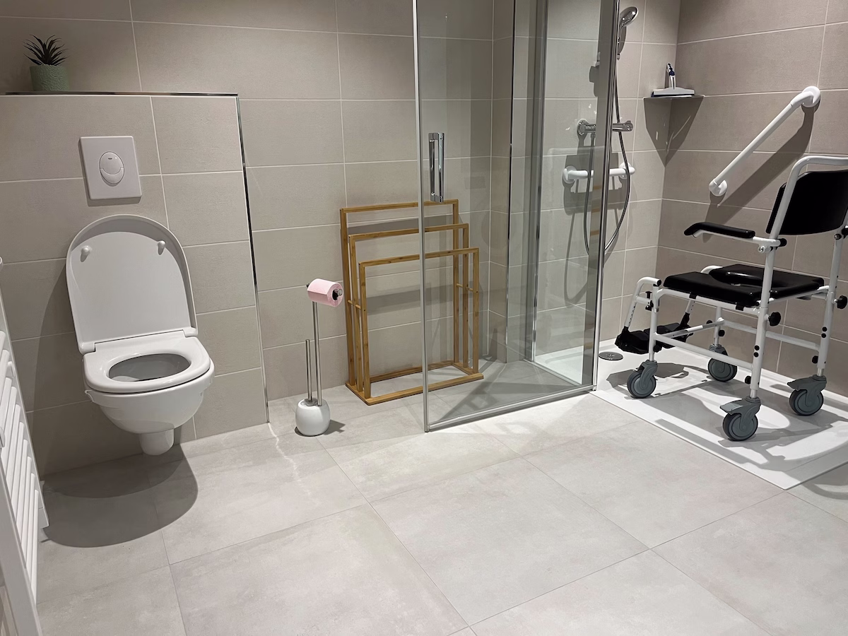Accessible bathroom with shower and toilet facilities.