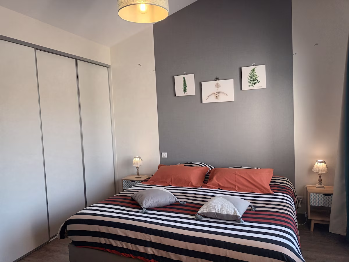 Cosy bedroom with modern decor and striped bedding.