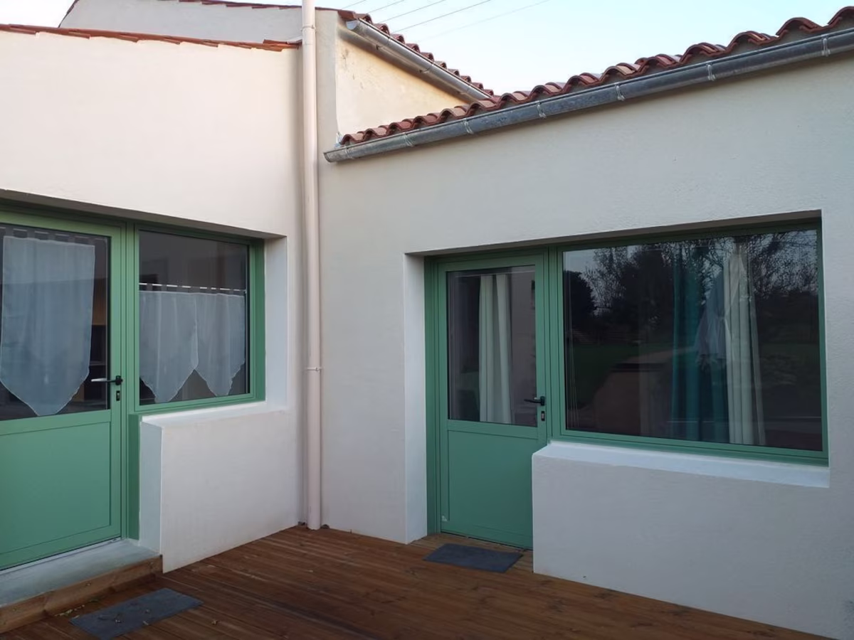 Modern house with green doors and windows.
