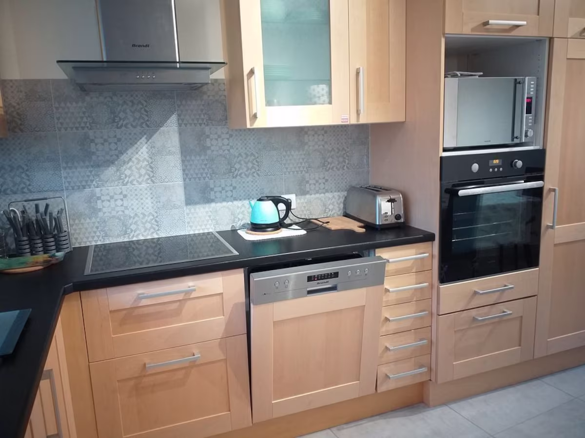 Modern kitchen with appliances and wooden cabinets.