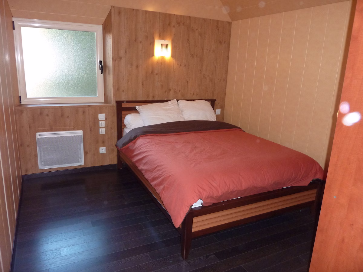 Cosy wooden bedroom with double bed.