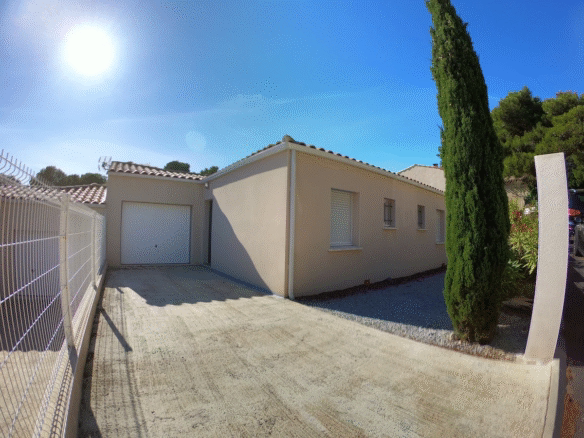 Single-storey house with garage and driveway in sunlight.
