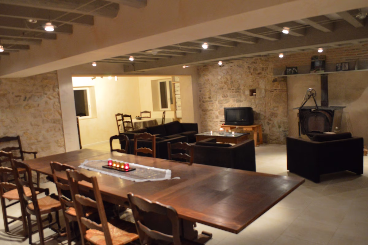 Spacious rustic dining room with stone walls.