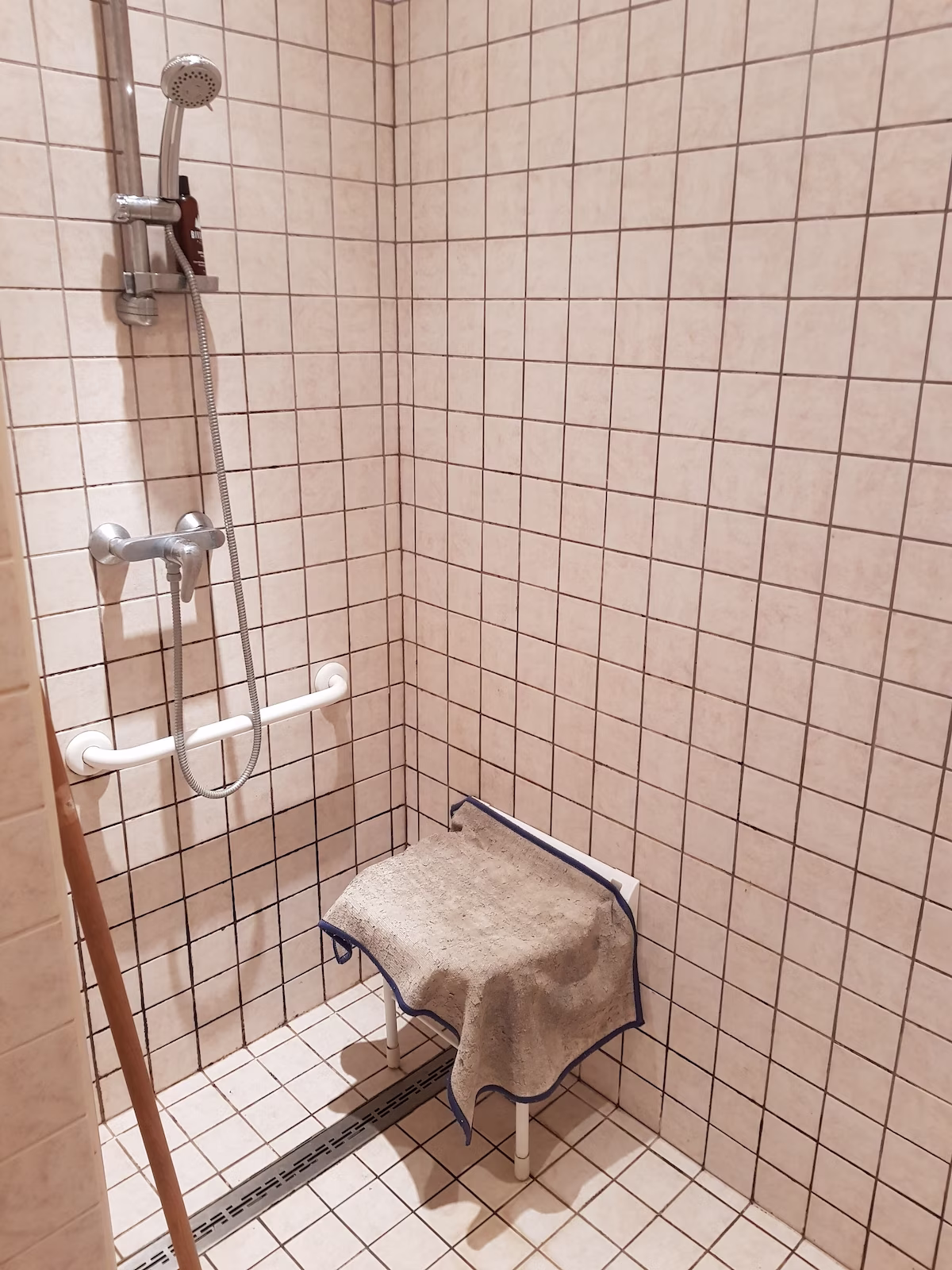 Accessible shower with seat and grab bar.