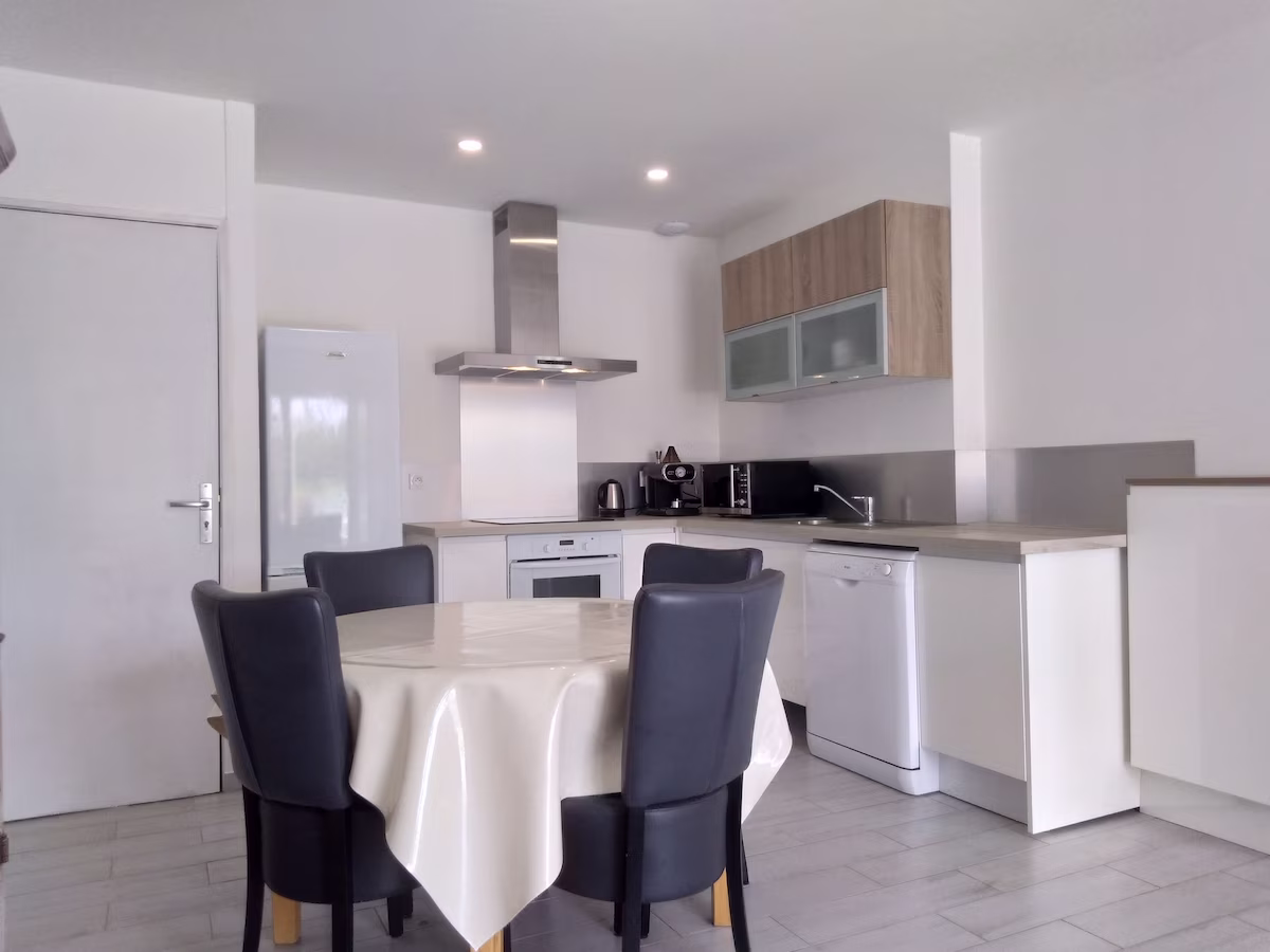 Modern kitchen with dining area and appliances.