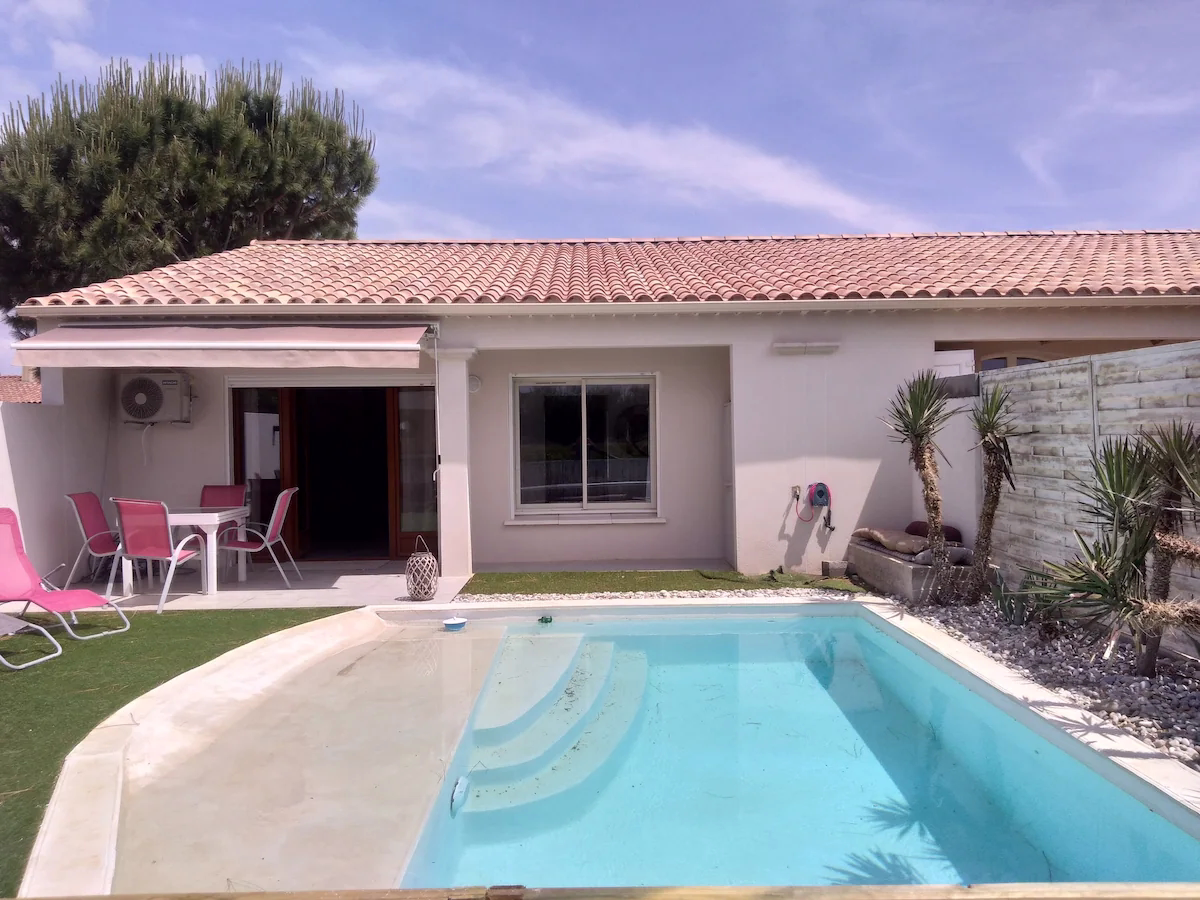 Modern bungalow with pool and patio area.
