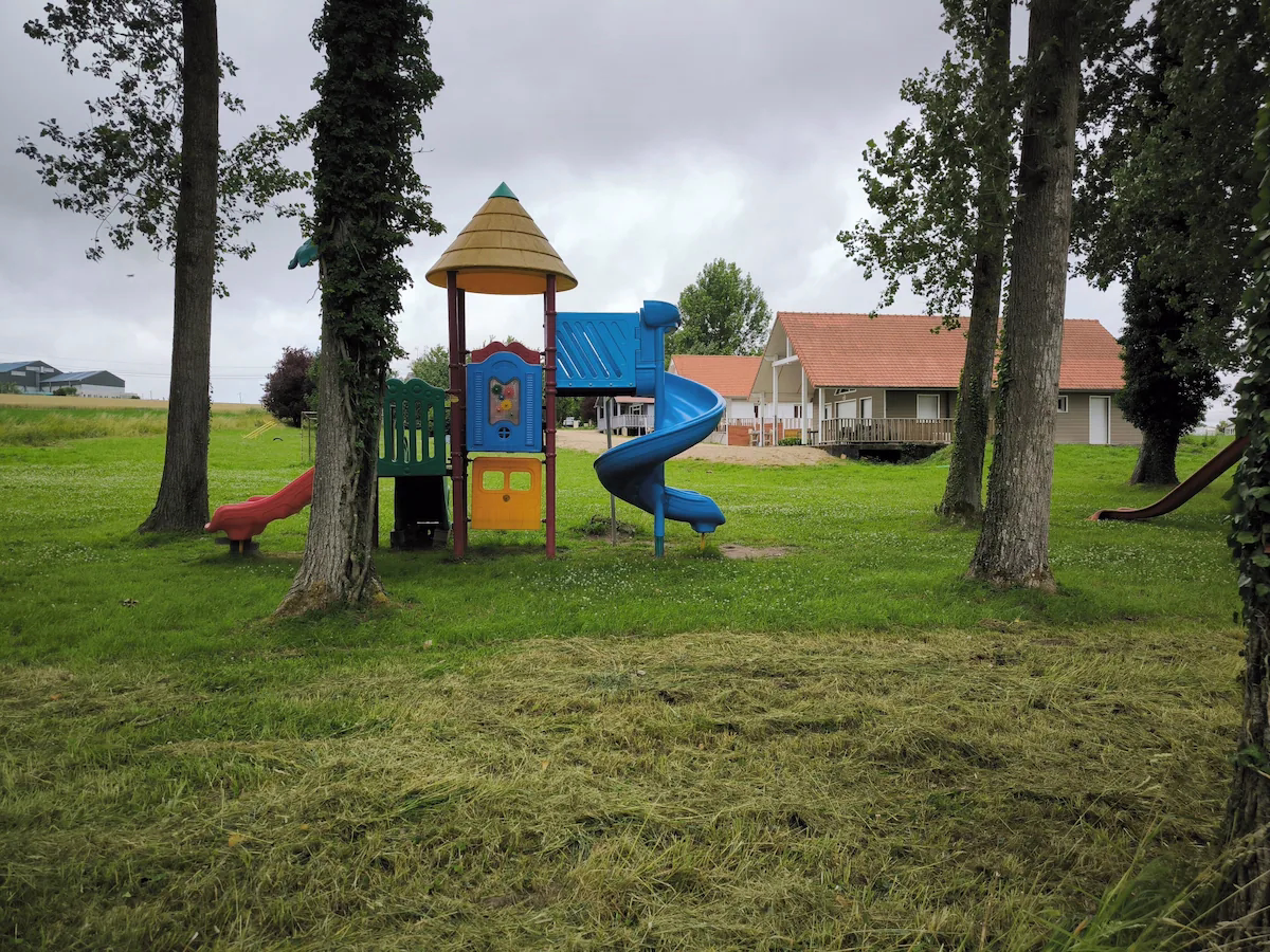 Colourful playground slide in grassy park area.