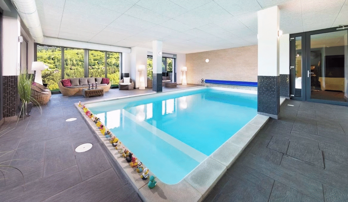 Indoor swimming pool with scenic garden view.