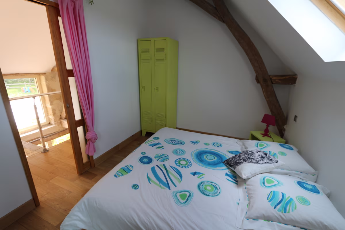 Bright attic bedroom with colourful decor and skylight.